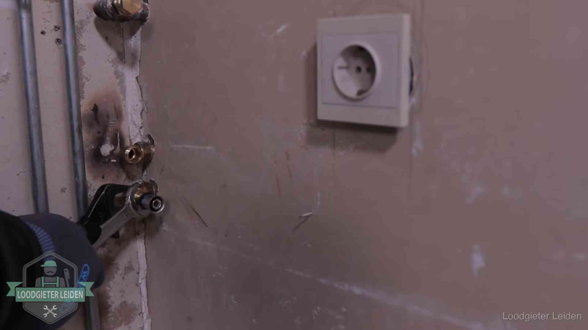 Erkend vakmanschap in Leiden Monteur draait een perskoppeling vast op een leidingaansluiting in Leiden
