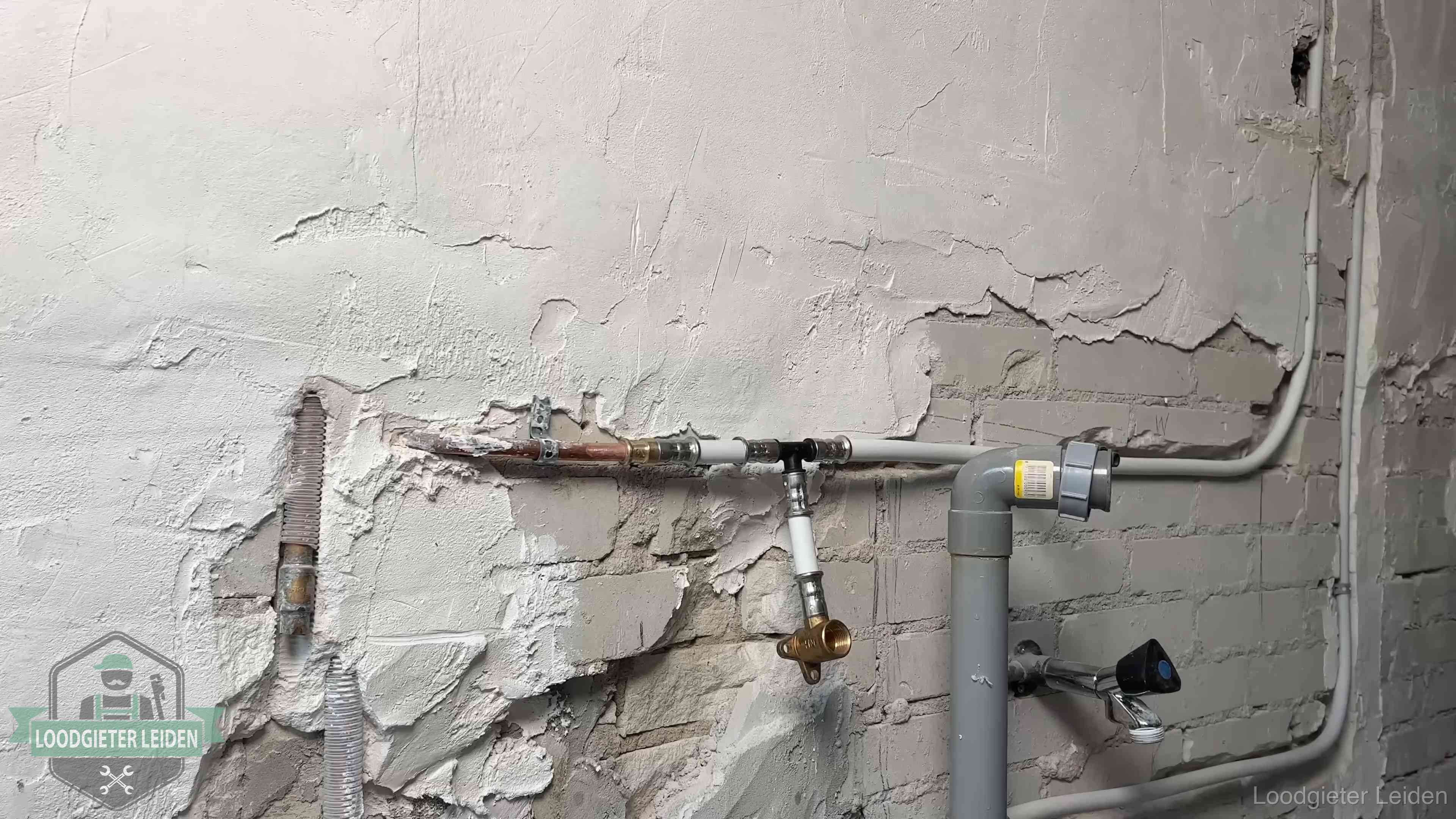 Leidingwerk in woningen in Leiden Nieuw leidingwerk naast een oud verroest leidingrestant in een woning in Leiden