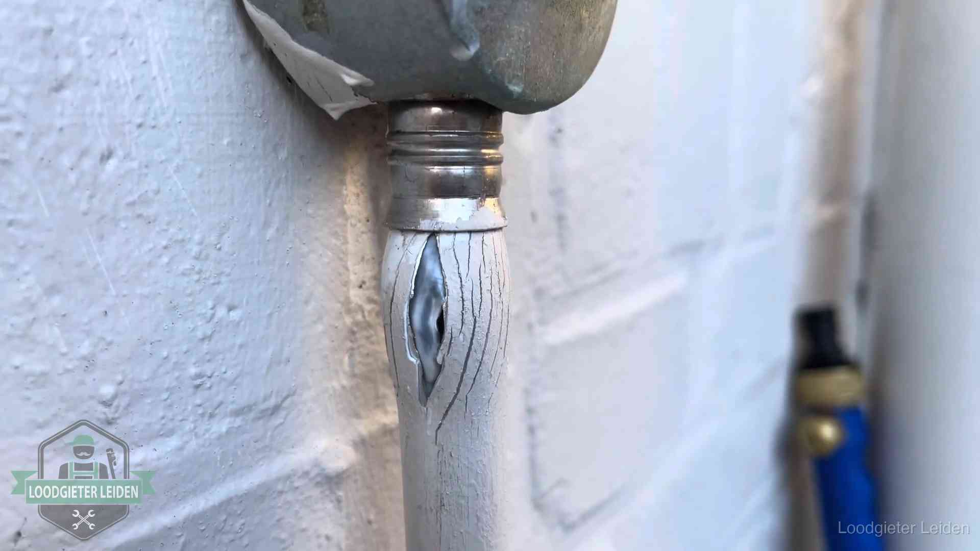 Oude waterleiding in Leiden waar de verf openscheurt, een stille aanwijzing voor een beginnend lek