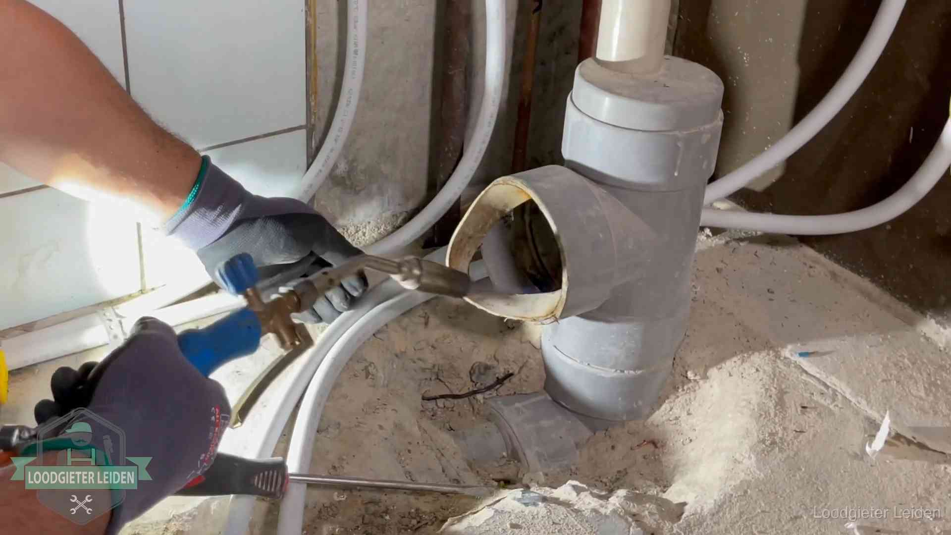 Vakmanschap van onze loodgieters in Leiden Loodgieter werkt met brander en messing kraanwerk aan leidingen in Leiden