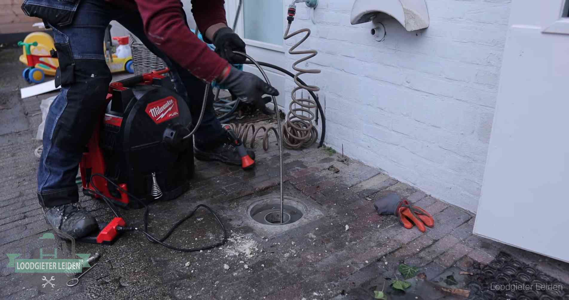 Erfgrens en gemeenteriool in Leiden Ontstoppingsputje in de bestrating naast de gevel van een woning in Leiden