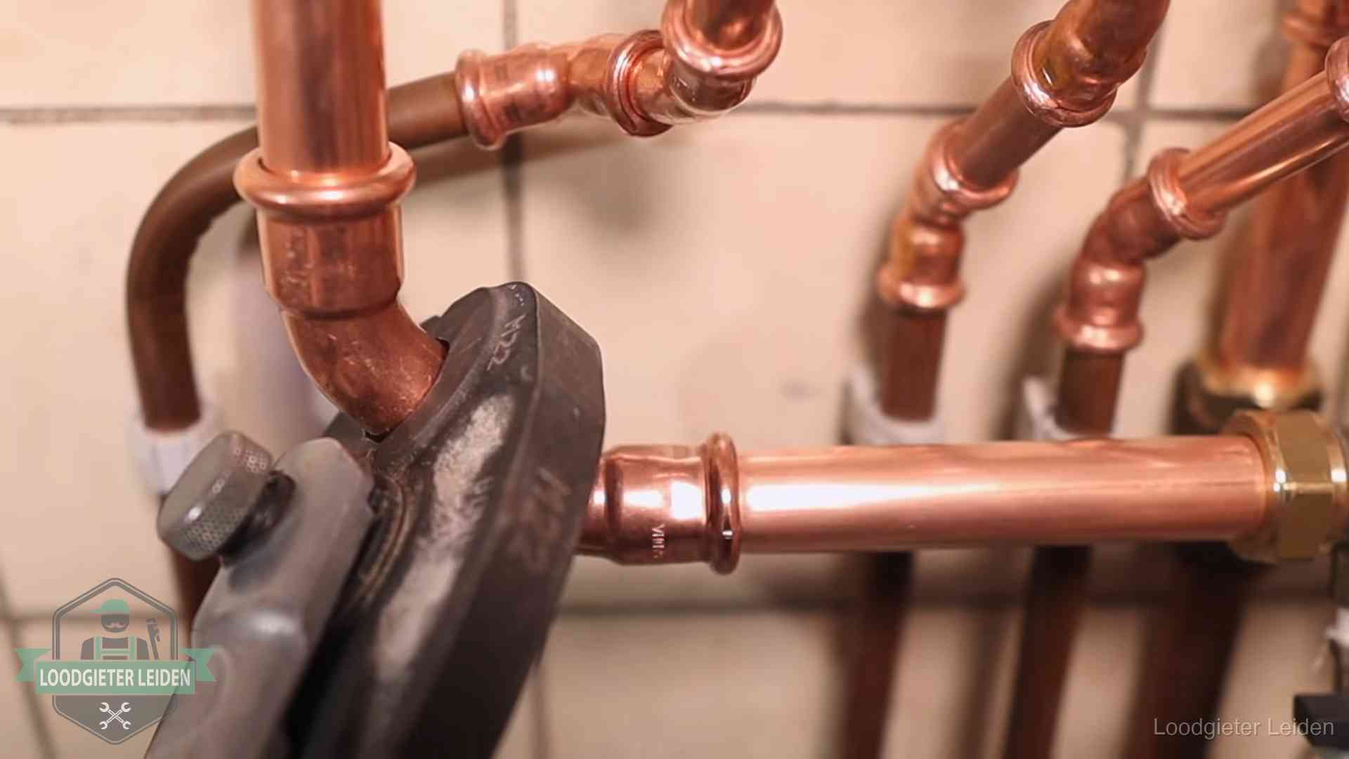 Werkwijze van ons loodgietersbedrijf in Leiden Persmachine perst een koperen fitting op nieuw leidingwerk in Leiden