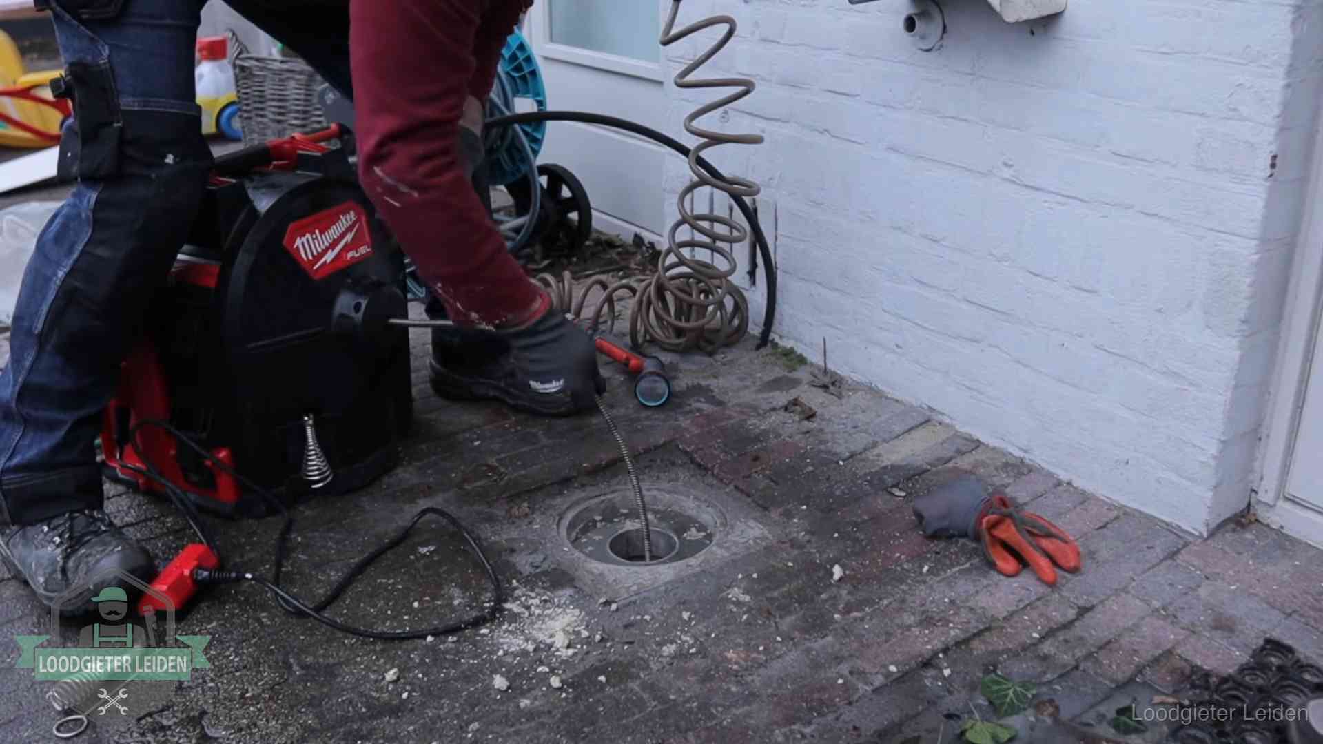 Prijs van een rioolontstopping in Leiden Spiraalmachine bij een ontstoppingsputje in de bestrating in Leiden
