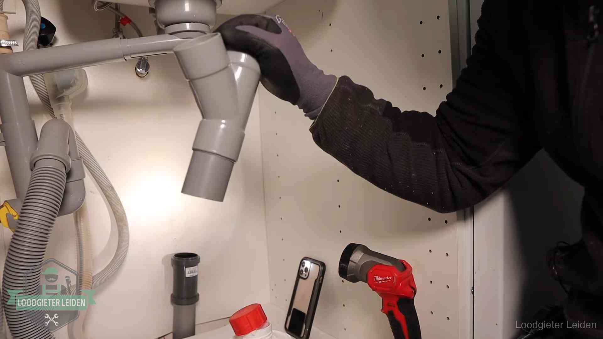 Rioollucht in huis verhelpen in Leiden Loodgieter demonteert het sifon- en afvoerwerk onder een gootsteen in Leiden bij stankklachten