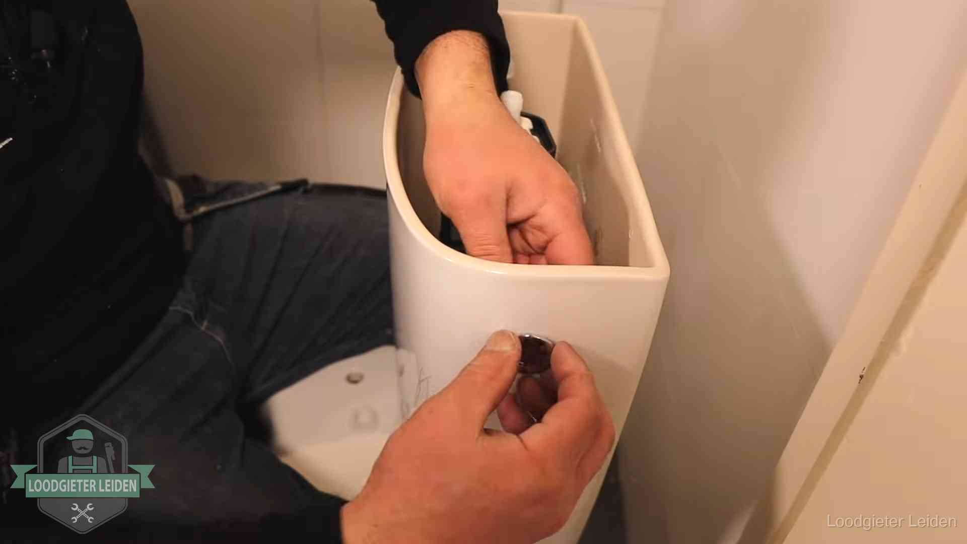 Je wc verstoppingsvrij houden in Leiden Drukknop van een duoblok-stortbak wordt gemonteerd bij een toilet in Leiden