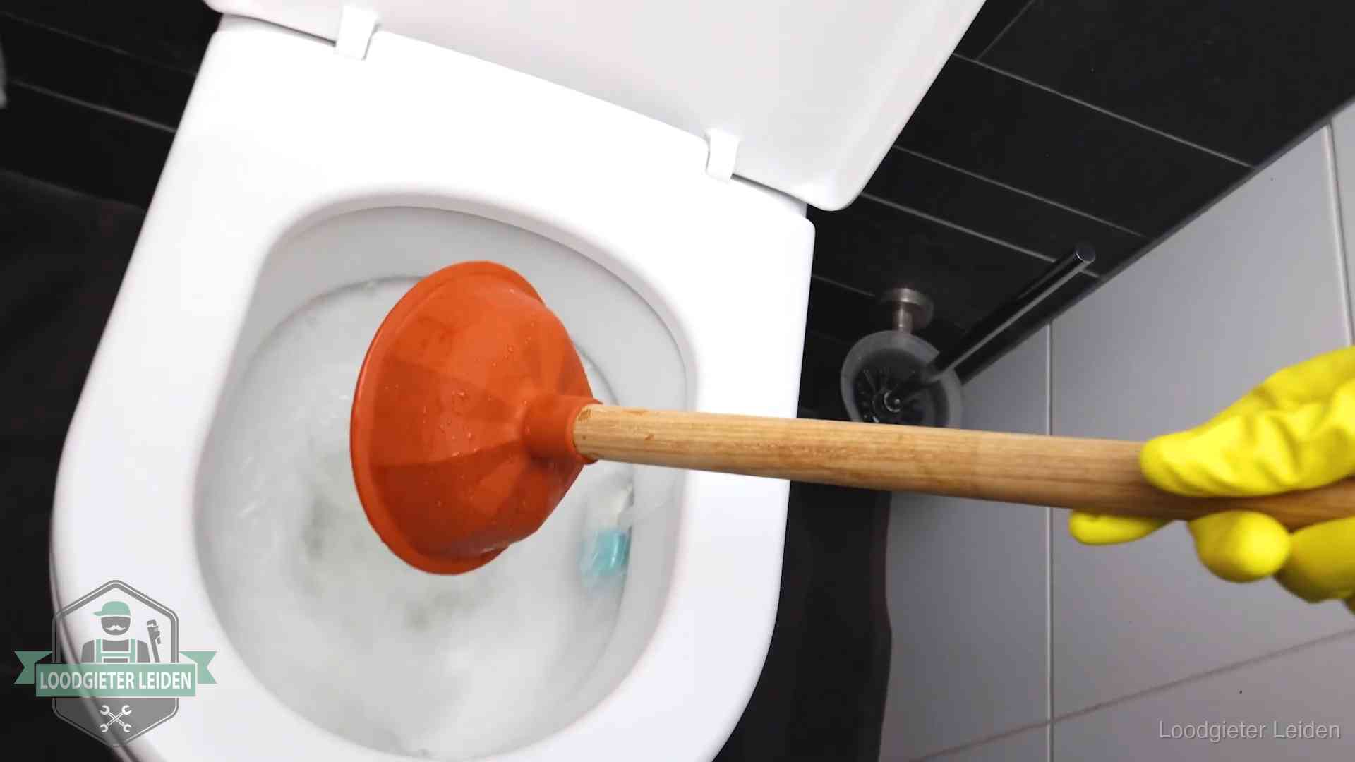 Wc ontstoppen met de plopper in Leiden Plopper wordt in de wc-pot gedrukt bij het ontstoppen van een toilet in Leiden