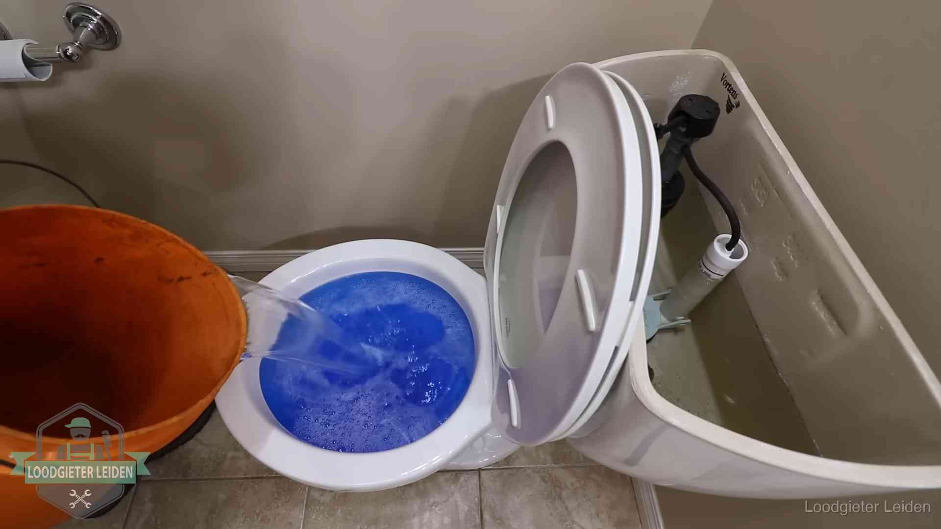 Water komt omhoog in de wc in Leiden Water bij de wc-pot wordt met een emmer weggewerkt om schade te beperken in Leiden